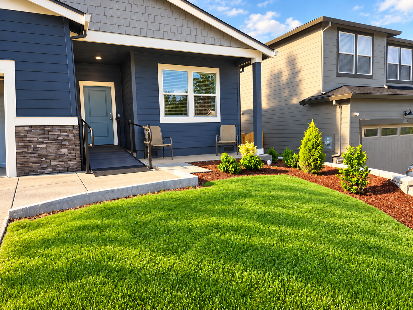 Front of the Misty Glen adult foster home in West Salem, a navy blue house with a green lawn and landscaped garden